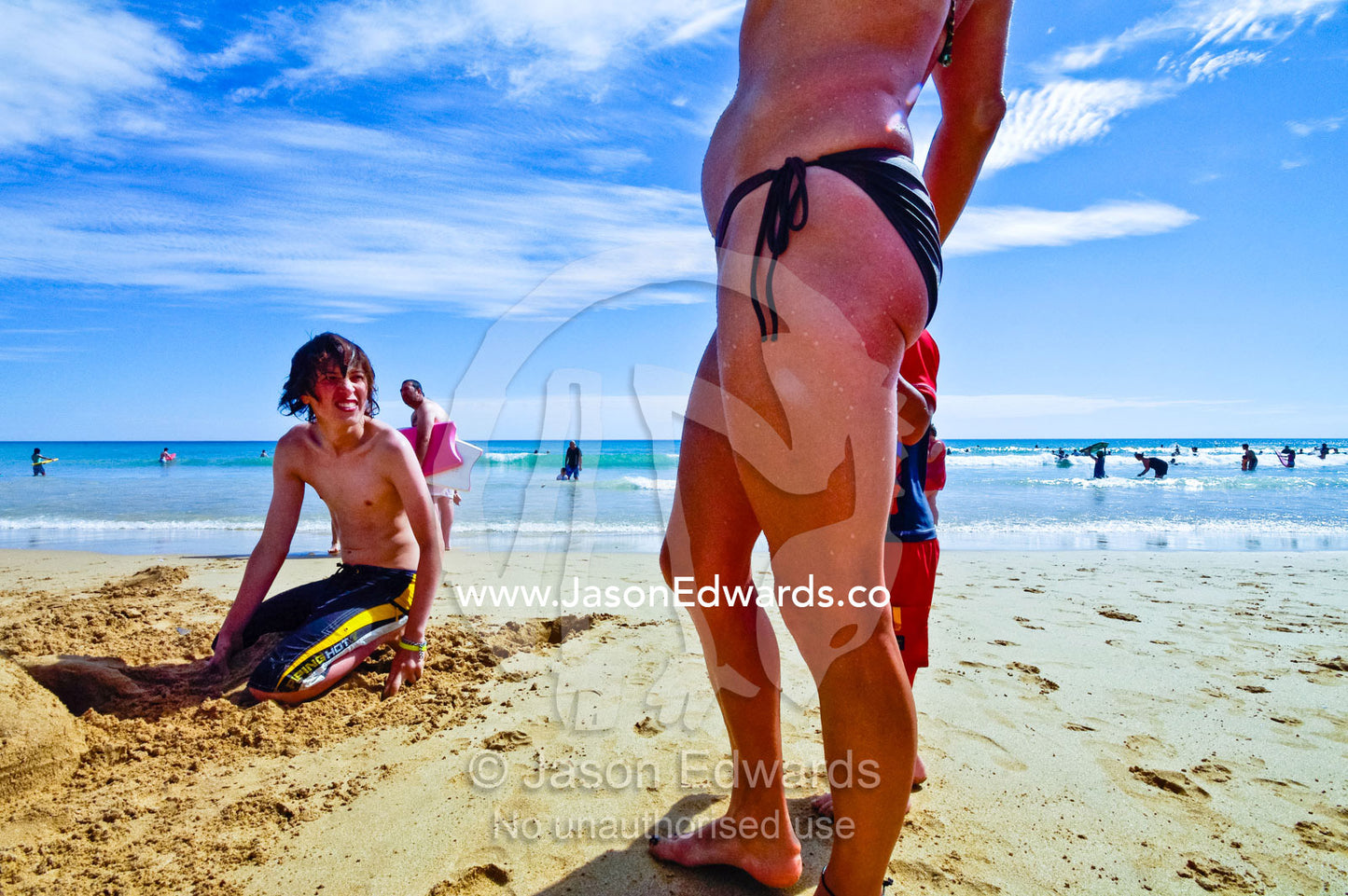 A teenage boy looking at an older woman in a bikini on the beach. Venus Bay, Cape Liptrap Coastal Park, Bass Strait, South Gippsland, Victoria, Australia.