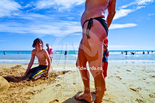 A teenage boy looking at an older woman in a bikini on the beach. Venus Bay, Cape Liptrap Coastal Park, Bass Strait, South Gippsland, Victoria, Australia.