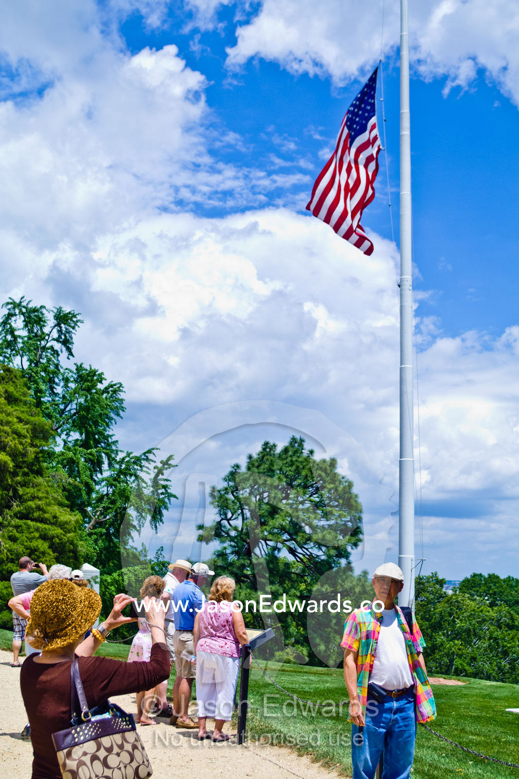 Tourists beneath the American flag at half mast on Memorial Day. Arlington National Cemetery, Arlington, Virginia, United States of America.