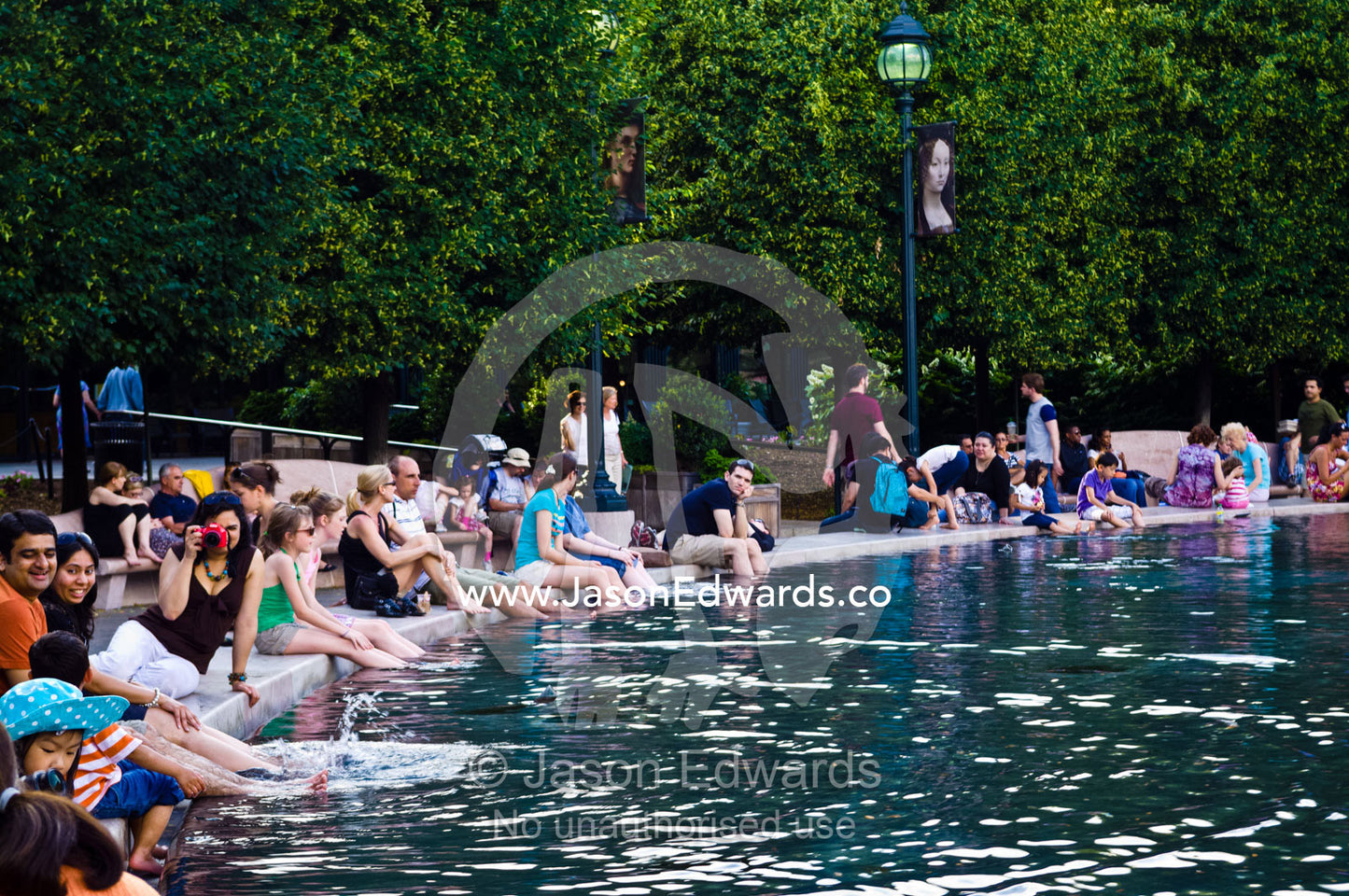 Tourists cool their feet in the fountain pool on Memorial Day. National Gallery of Art, National Mall, Washington, District of Columbia, United States of America.