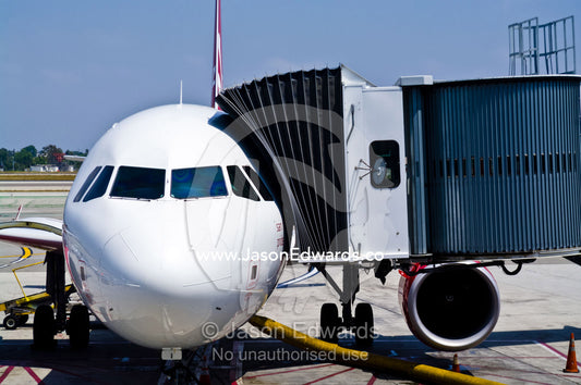 A passenger jet cockpit connected to a gantry for passengers to load. LAX Los Angeles International Airport, Los Angeles, California, United States of America.