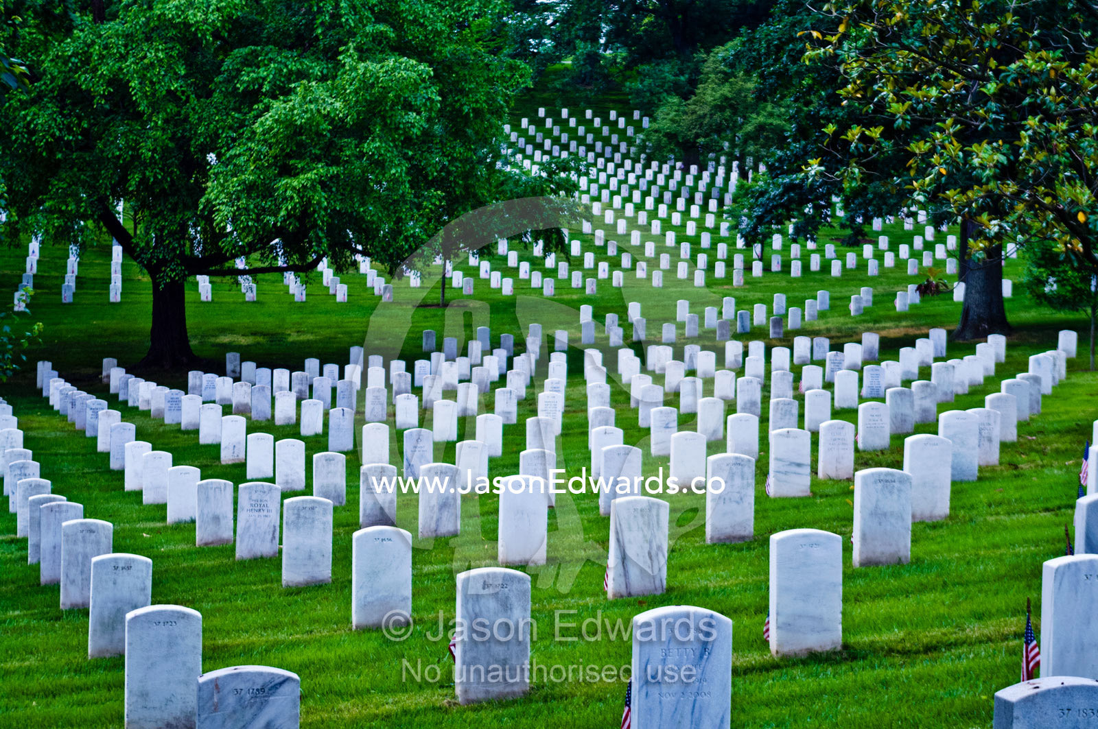 White marble tombstones mark graves of fallen soldiers in a cemetery. Arlington National Cemetery, Arlington, Virginia, United States of America.