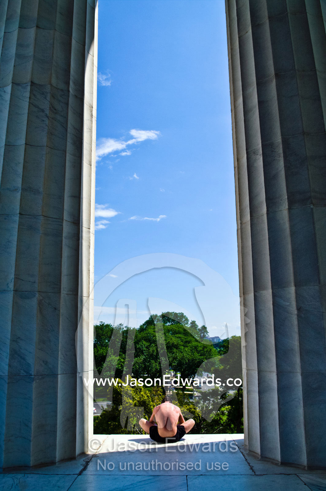 A runner rests between the Doric columns of the Lincoln Memorial. Lincoln Memorial, National Mall, Washington, District of Columbia, United States of America.