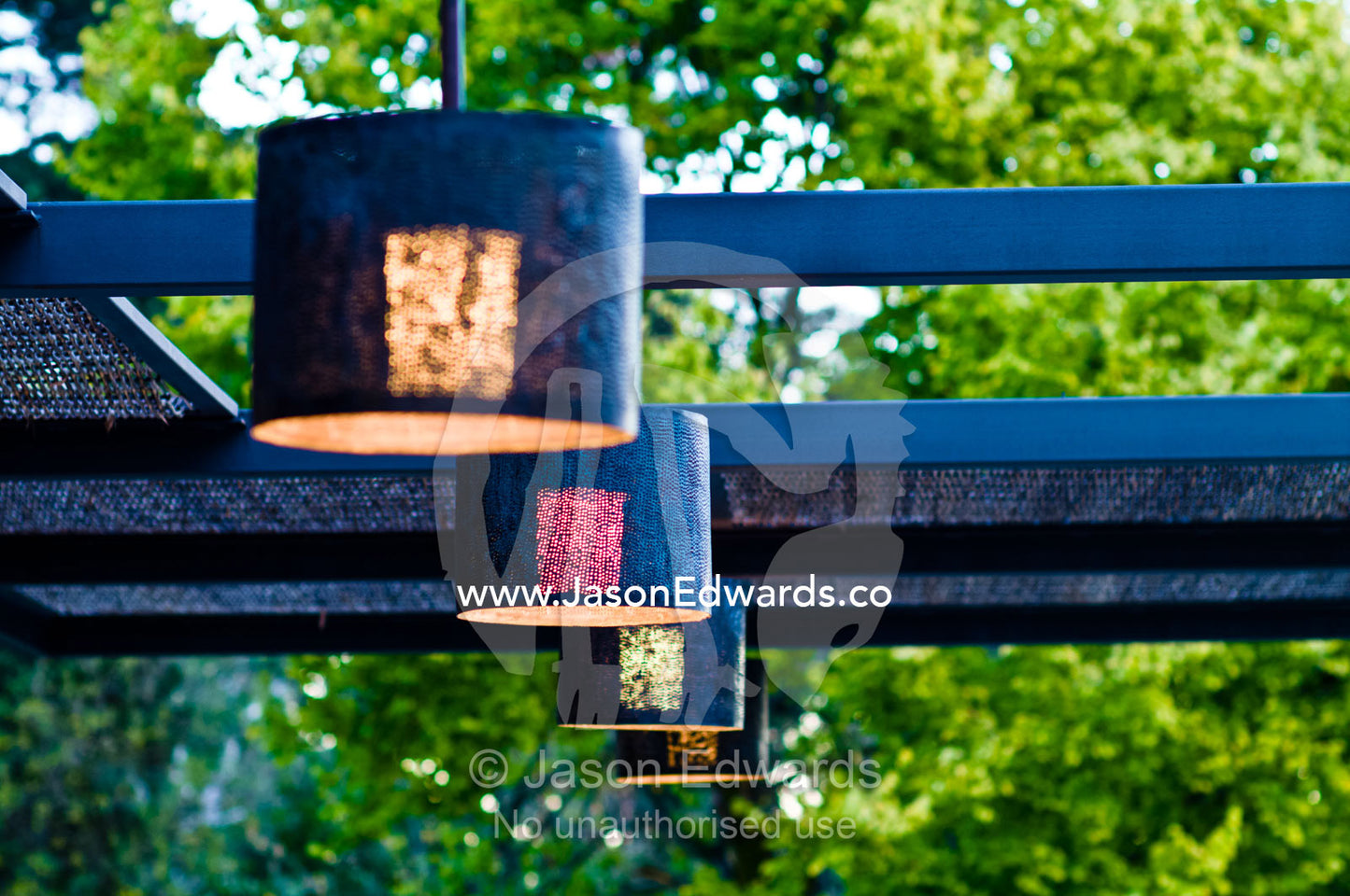Elegant brass lighting fixtures hang from beams over an outdoor patio. Hawthorn, Melbourne, Victoria, Australia.
