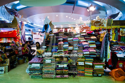A temporary stall in a shopping mall sells discounted silk pashminas. MBK Centre, Mahboonkrong Shopping Center, Bangkok, Thailand.