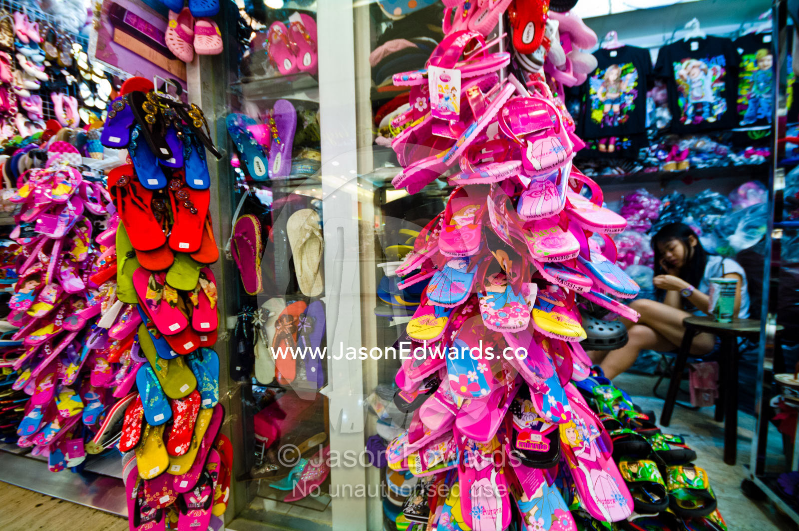 Discount flip-flops hang on racks for sale in a shopping mall. MBK Centre, Mahboonkrong Shopping Center, Bangkok, Thailand.