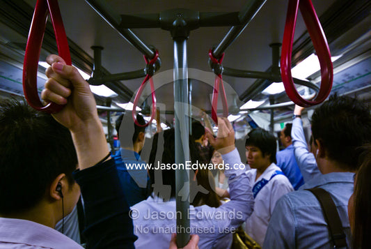 Rush hour office commuters on a crowded city train in Bangkok. Bangkok, Thailand.