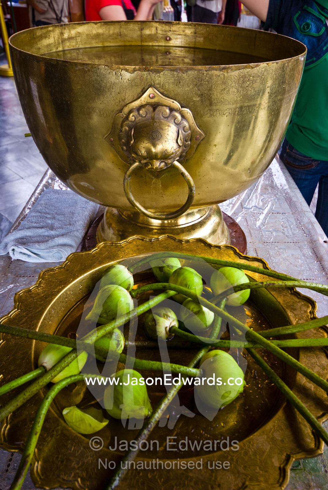 Flower bulbs and holy water in a brass urn for prayer offerings. Wat Phra Kaew, Wat Phra Kaeo, Temple of the Emerald Buddha, Bangkok, Thailand.