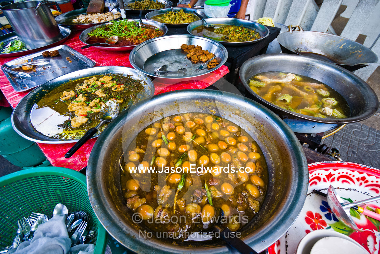 Large silver bowls contain curry and spicy eggs, chicken and seafood. Phra Nakhon District, Rattanakosin District, Bangkok, Thailand.