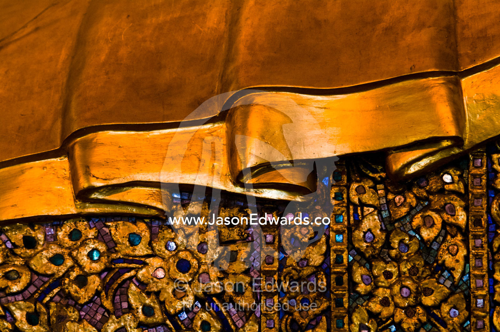 A detail of the golden and inlay robe worn by the Reclining Buddha. Wat Pho, Temple of the Reclining Buddha, Wat Chetuphon, Phra Nakhon District, Rattanakosin District, Bangkok, Thailand.