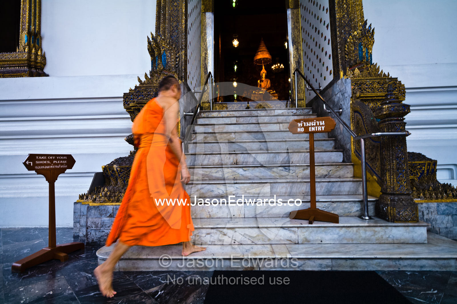 A Buddhist monk enters the Ubosot, the chapel, for evening prayers Wat Pho, Temple of the Reclining Buddha, Wat Chetuphon, Phra Nakhon District, Rattanakosin District, Bangkok, Thailand.