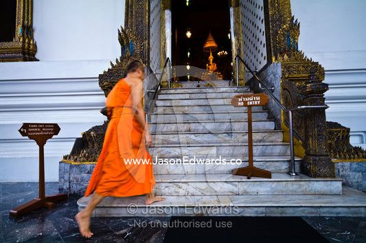 A Buddhist monk enters the Ubosot, the chapel, for evening prayers Wat Pho, Temple of the Reclining Buddha, Wat Chetuphon, Phra Nakhon District, Rattanakosin District, Bangkok, Thailand.