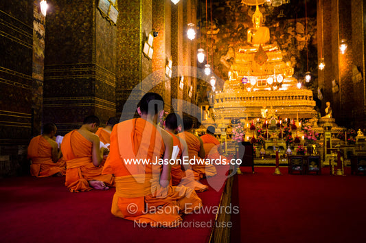 Buddhist monks in deep prayer in the Ubosot, the temple's chapel. Wat Pho, Temple of the Reclining Buddha, Wat Chetuphon, Phra Nakhon District, Rattanakosin District, Bangkok, Thailand.