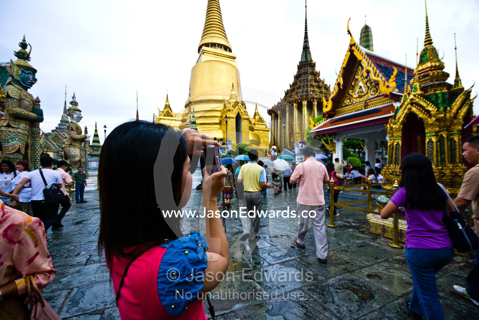 Crowds of Thai tourists and worshippers photograph Buddhist temples. Prasat Phra Thep Bidon, Royal Pantheon, Wat Phra Kaew, Wat Phra Kaeo, Temple of the Emerald Buddha, Bangkok, Thailand.
