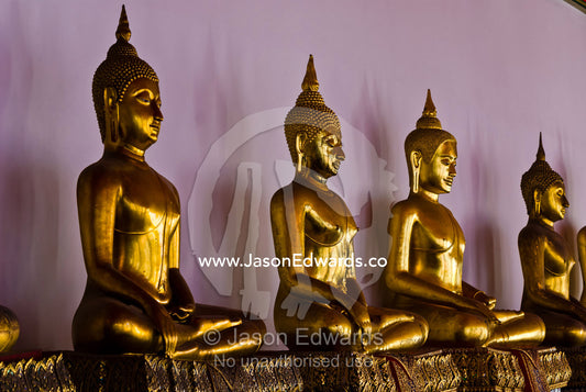 Gilded golden statues of the Buddha seated in a temple. Wat Pho, Temple of the Reclining Buddha, Wat Chetuphon, Phra Nakhon District, Rattanakosin District, Bangkok, Thailand.
