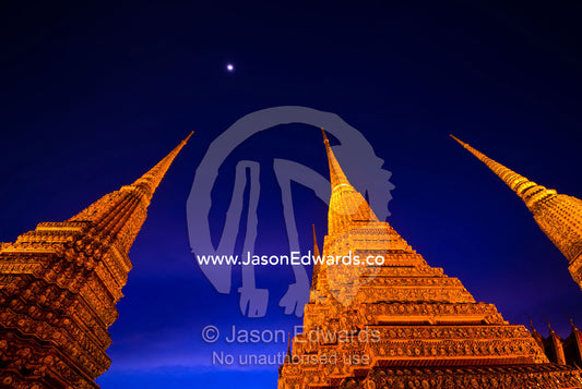 Moonrise over the prang of the Phra Maha Chedi rising into night sky. Wat Pho, Phra Maha Chedi, Bangkok, Thailand.