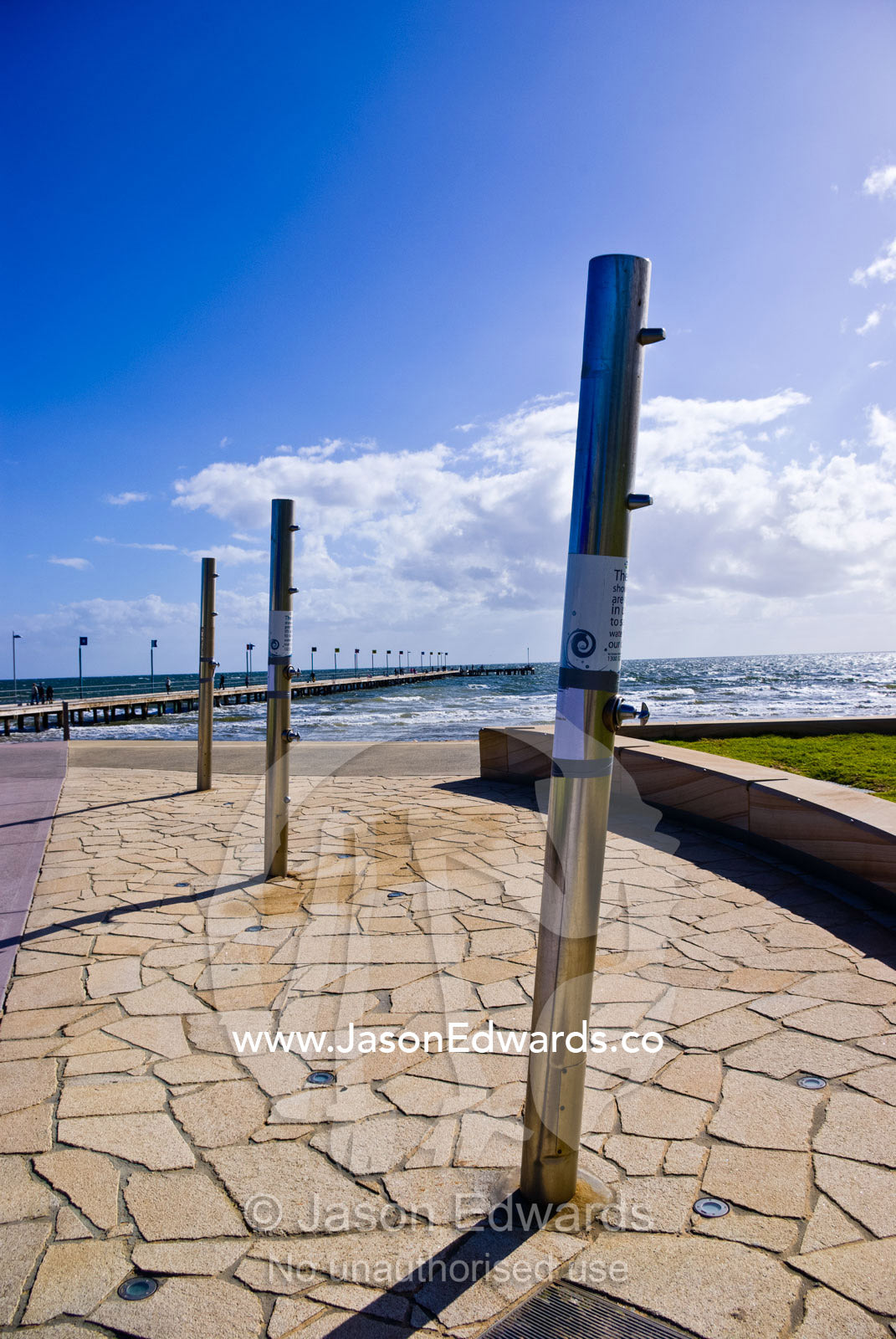Stainless steel showers by the beach for bathing after an ocean swim. Frankston, Port Phillip Bay, Melbourne, Victoria, Australia.