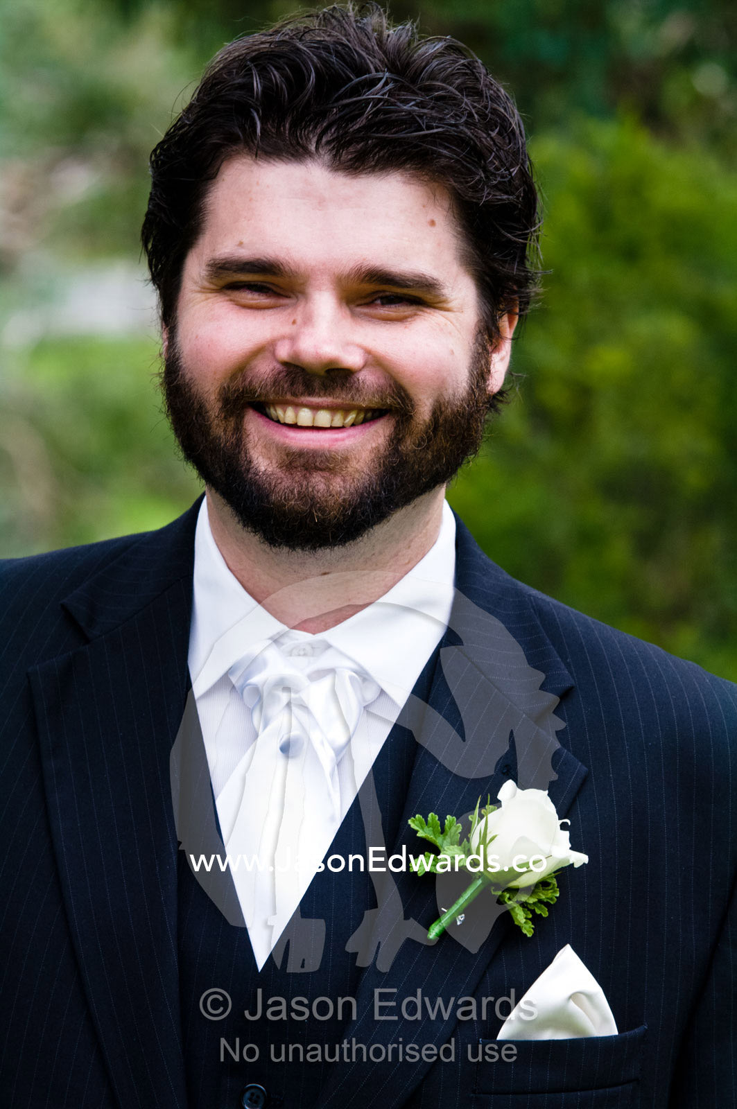 A smiling groom awaits the arrival of his bride at a garden wedding. Park Orchards, Melbourne, Victoria, Australia.