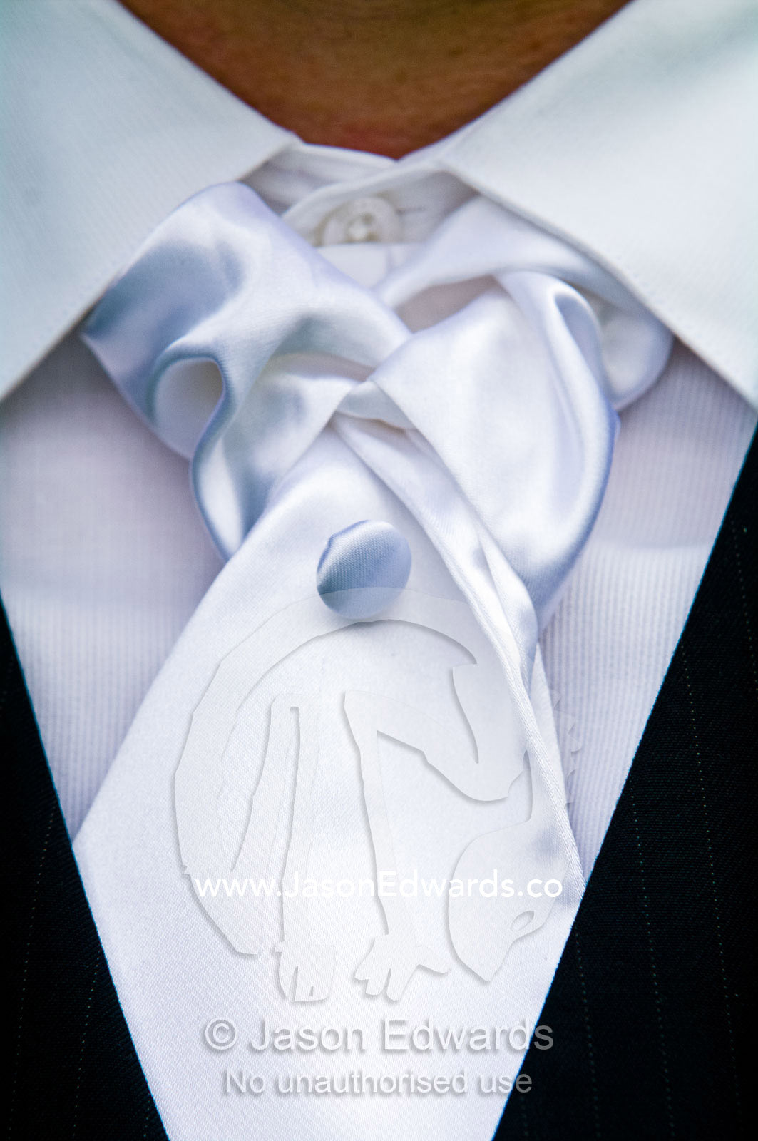 Detail of a white silk tie and suit worn by a groom at a wedding. Park Orchards, Melbourne, Victoria, Australia.