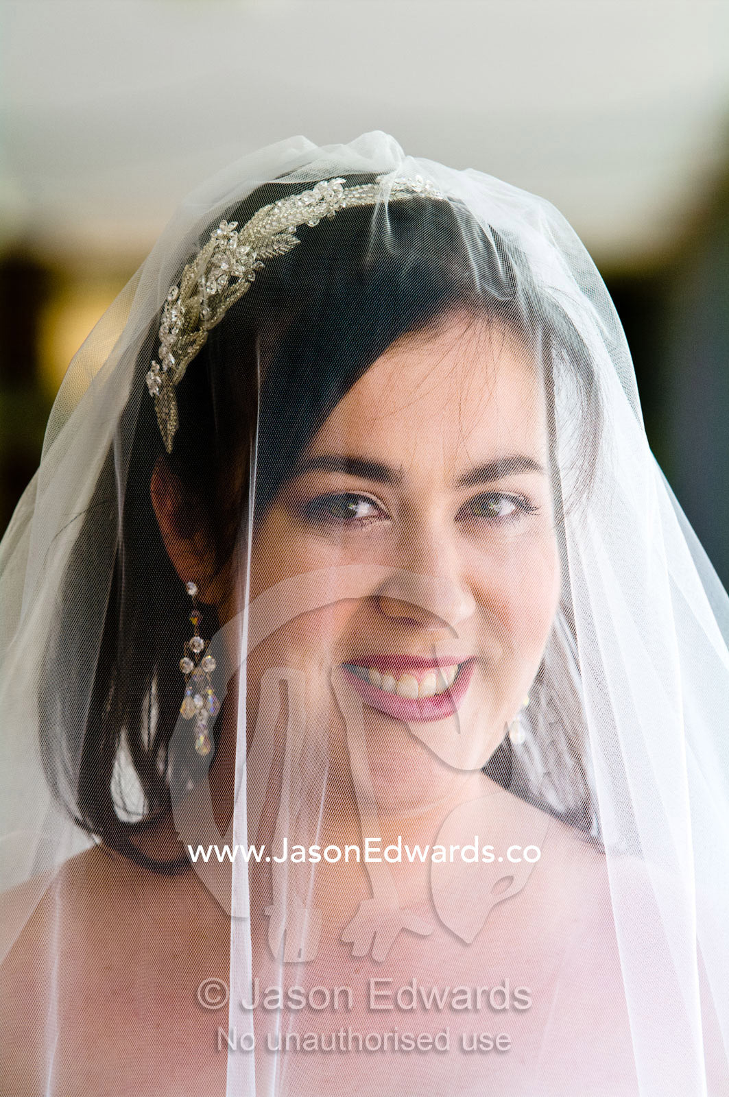 A glowing bride smiles beneath her veil on her wedding day. Park Orchards, Melbourne, Victoria, Australia.