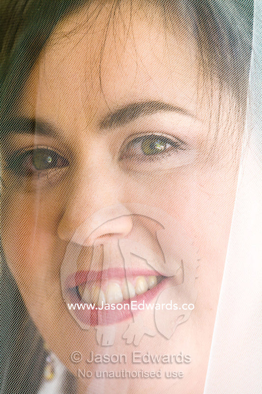 A glowing bride smiles beneath her veil on her wedding day. Park Orchards, Melbourne, Victoria, Australia.