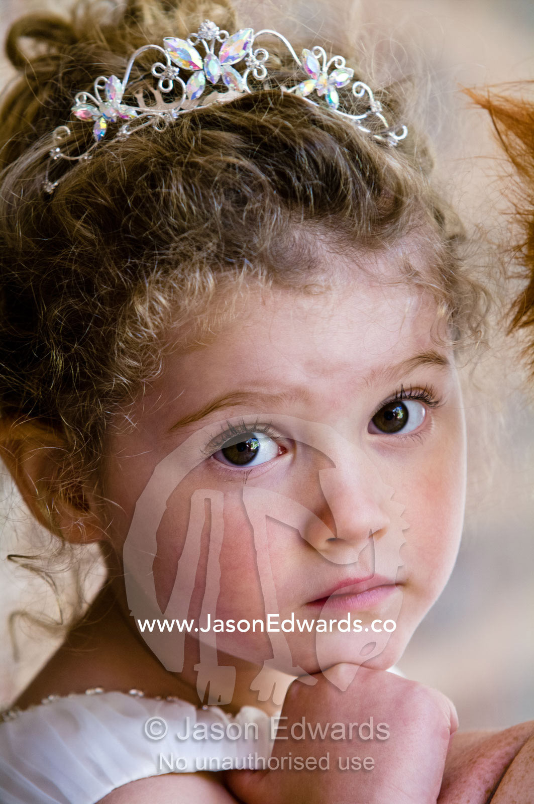 An innocent wide-eyed flower girl in a tiara at a wedding. Park Orchards, Melbourne, Victoria, Australia.