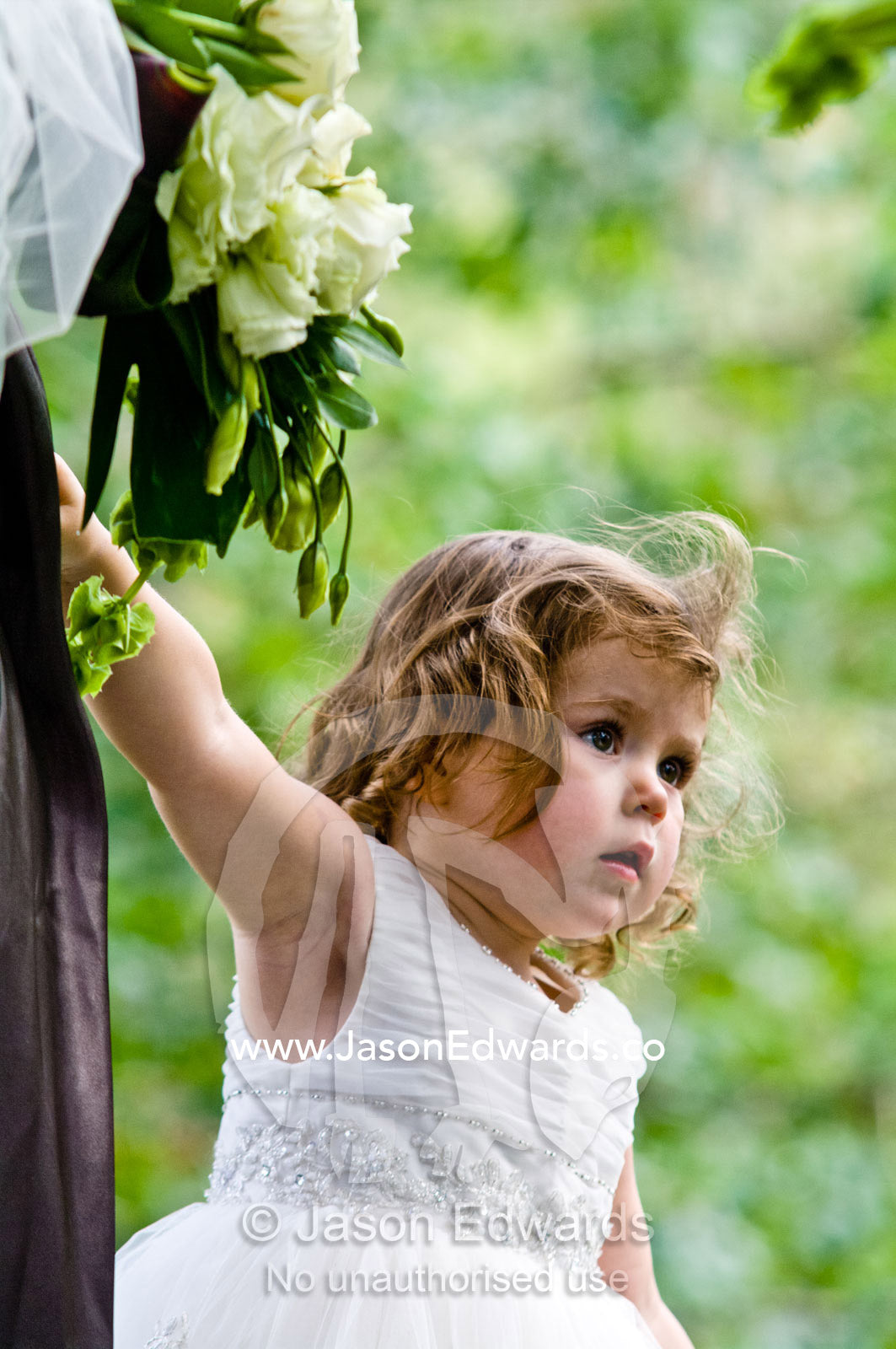 A flower girl holds her bridesmaid mothers hand at a garden wedding. Park Orchards, Melbourne, Victoria, Australia.