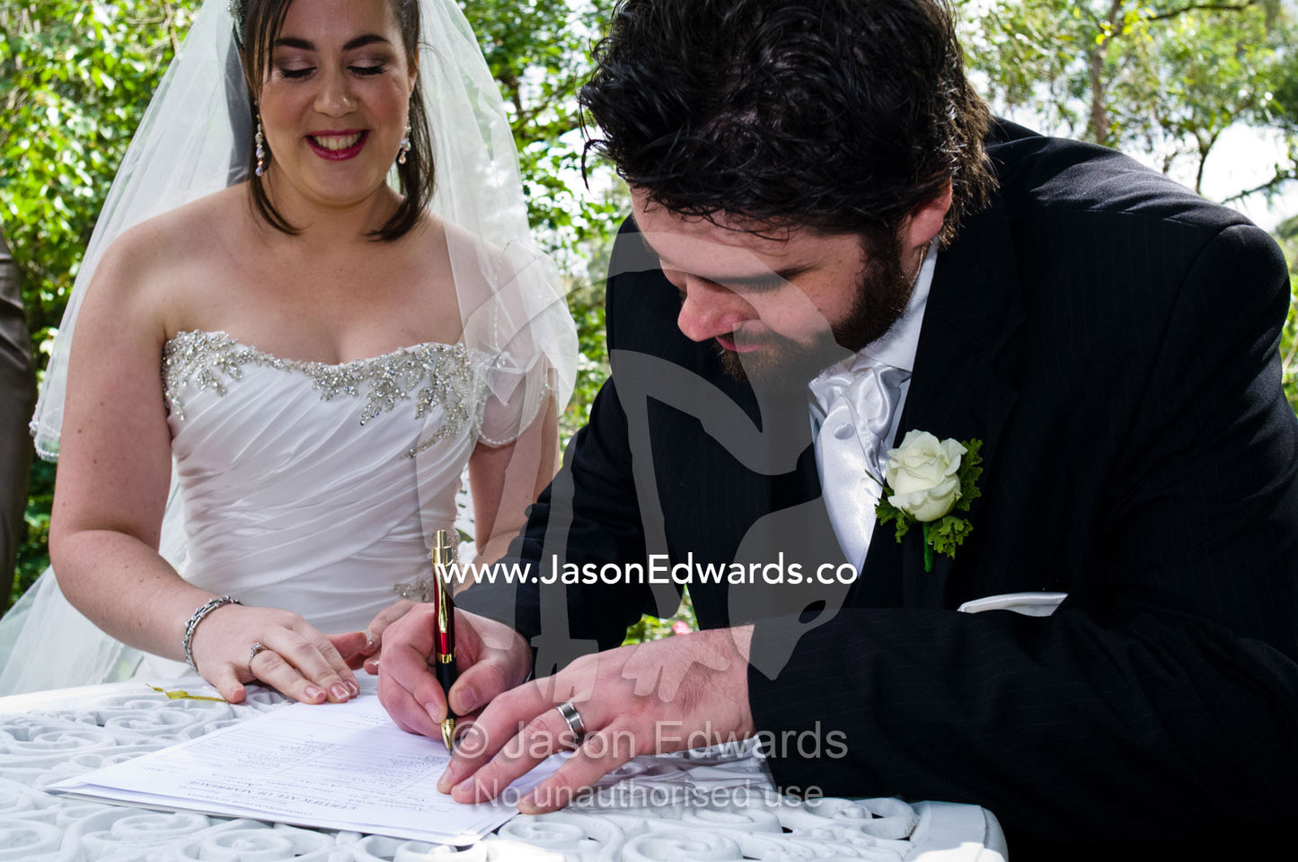 A bride and groom sign legal documents to formalise their wedding. Park Orchards, Melbourne, Victoria, Australia.