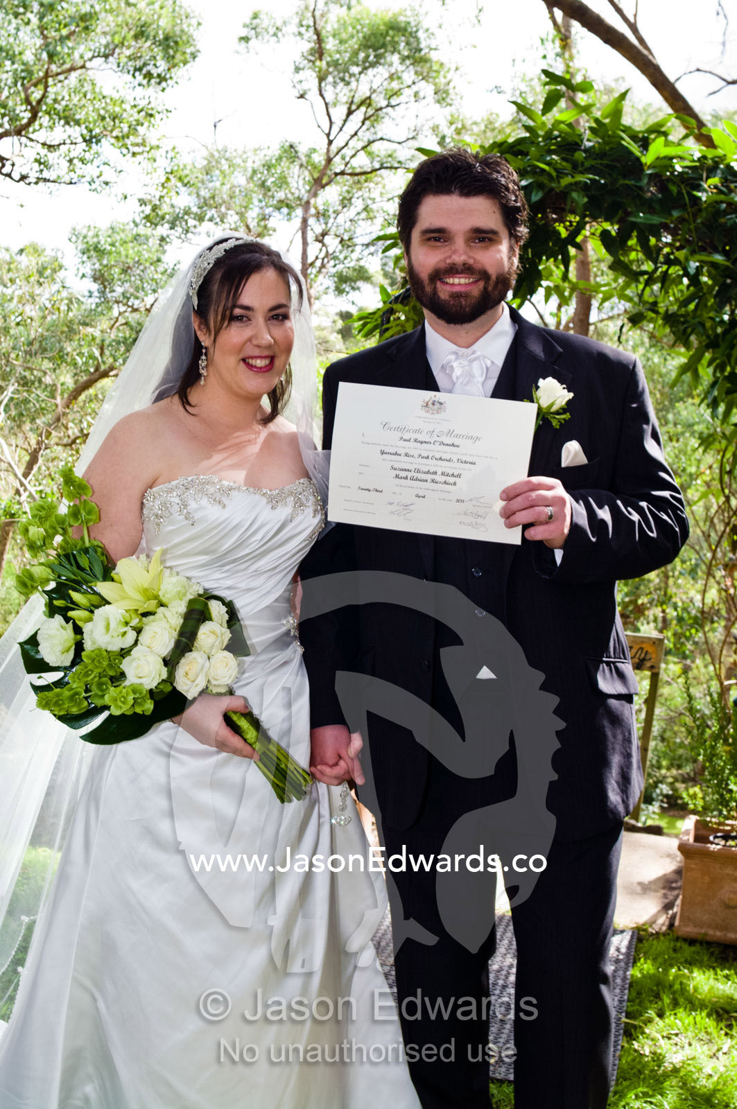 A happy bride and groom proudly display their marriage certificate. Park Orchards, Melbourne, Victoria, Australia.