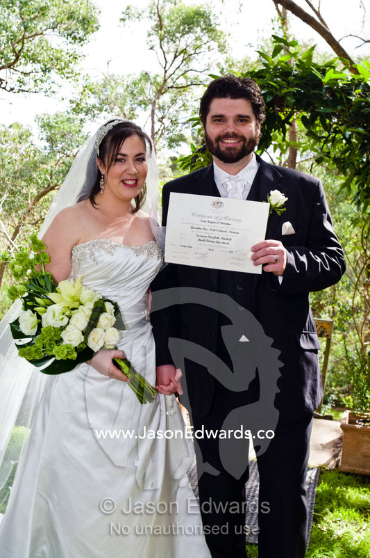 A happy bride and groom proudly display their marriage certificate. Park Orchards, Melbourne, Victoria, Australia.