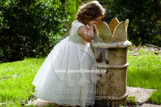 Inquisitive flower girl peers inside a sculpture at a garden wedding. Park Orchards, Melbourne, Victoria, Australia.