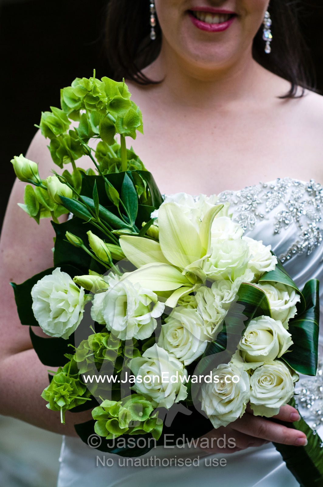A bride holds her bouquet of roses and lilies on her wedding day. Park Orchards, Melbourne, Victoria, Australia.