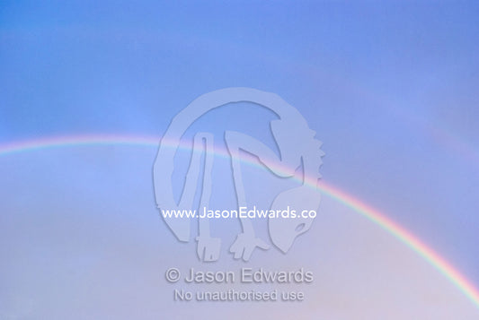 The prism of an iridescent rainbow arching through a stormy sky. North Carlton, Melbourne, Victoria, Australia.