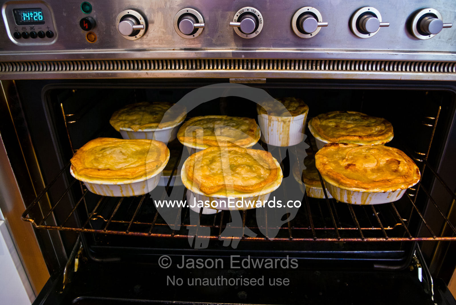 Freshly baked chicken pies cooling on an oven rack in a kitchen. Malvern East, Melbourne, Victoria, Australia.