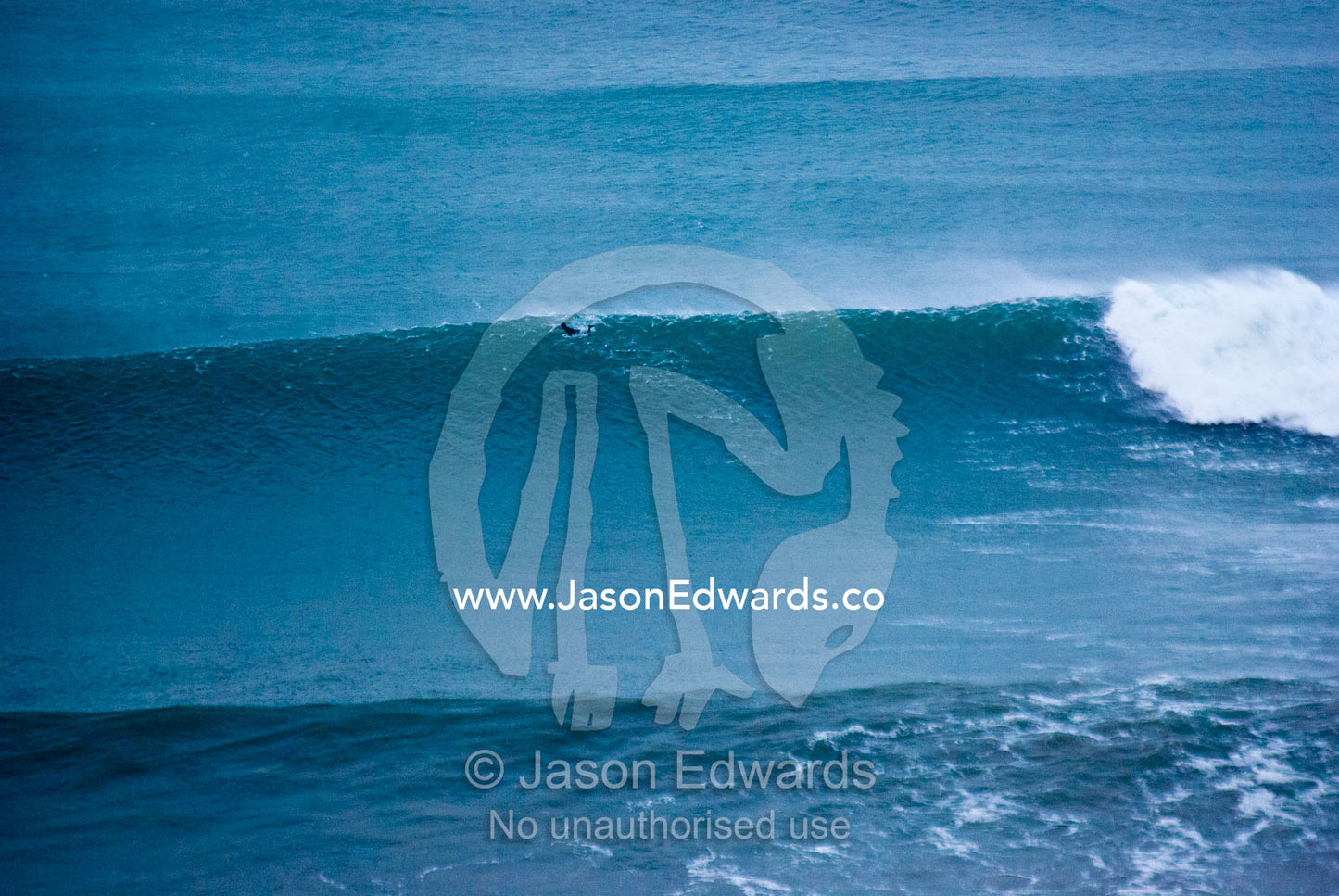 A lone surfer braves huge waves during a winter swell at Bells Beach. Bells Beach Surfing Recreation Reserve, Surf Coast, Victoria, Australia.