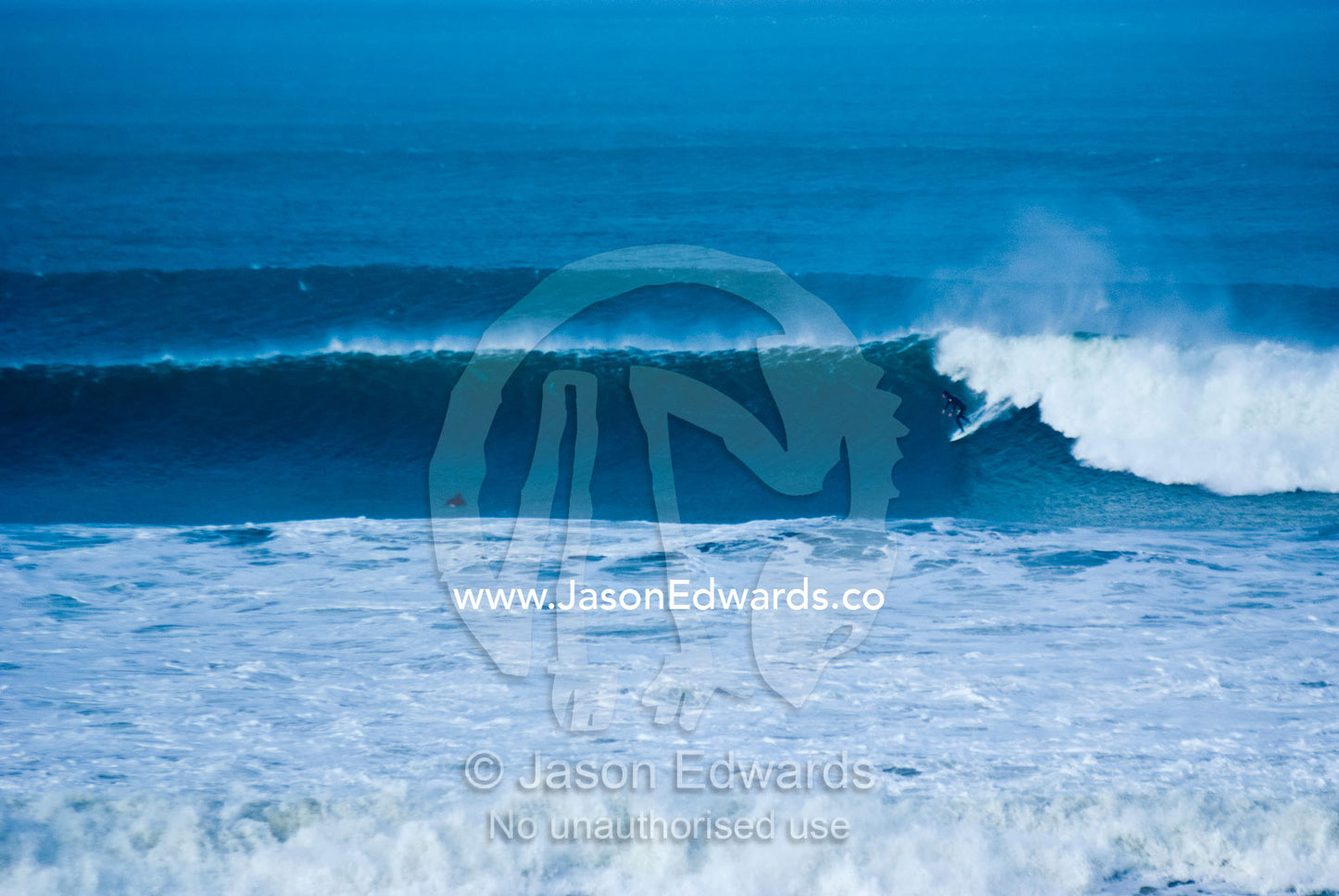 A lone surfer braves huge waves during a winter swell at Bells Beach. Bells Beach Surfing Recreation Reserve, Surf Coast, Victoria, Australia.