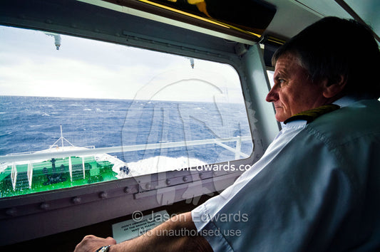 A captain on the bridge as the ship rounds treacherous Cape Horn. Drake Passage, Cape Horn, Tierra del Fuego, Hornos Island, Chile.