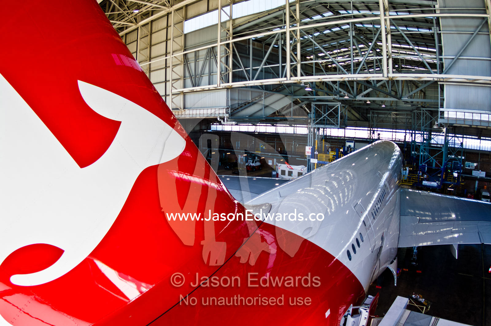 A kangaroo logo on a jet airliner parked in a hanger for repairs. Kingsford Smith Airport, Mascot, Sydney, New South Wales, Australia.
