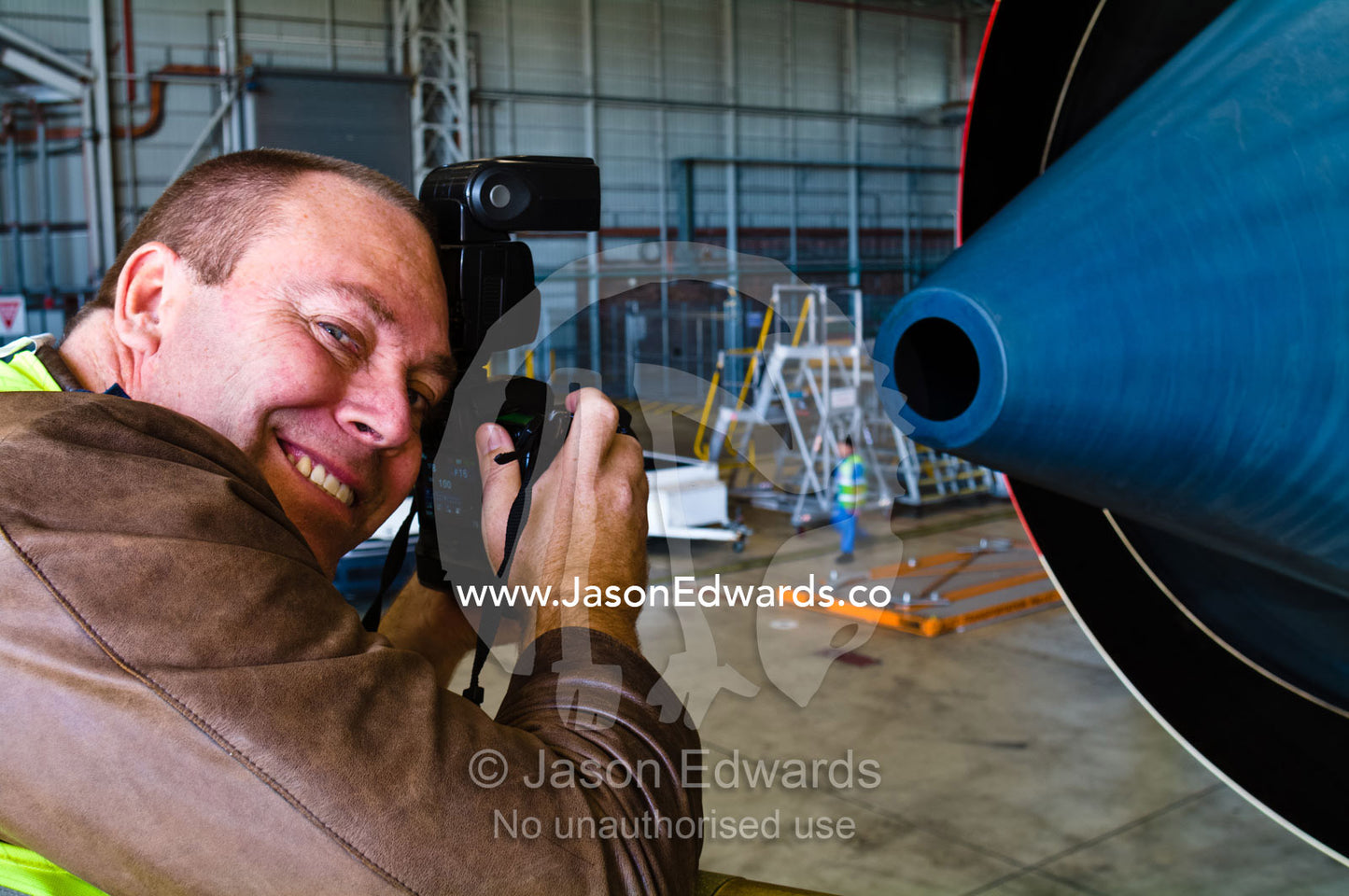 A photographer captures images of a jet airliner engine exhaust. Kingsford Smith Airport, Mascot, Sydney, New South Wales, Australia.