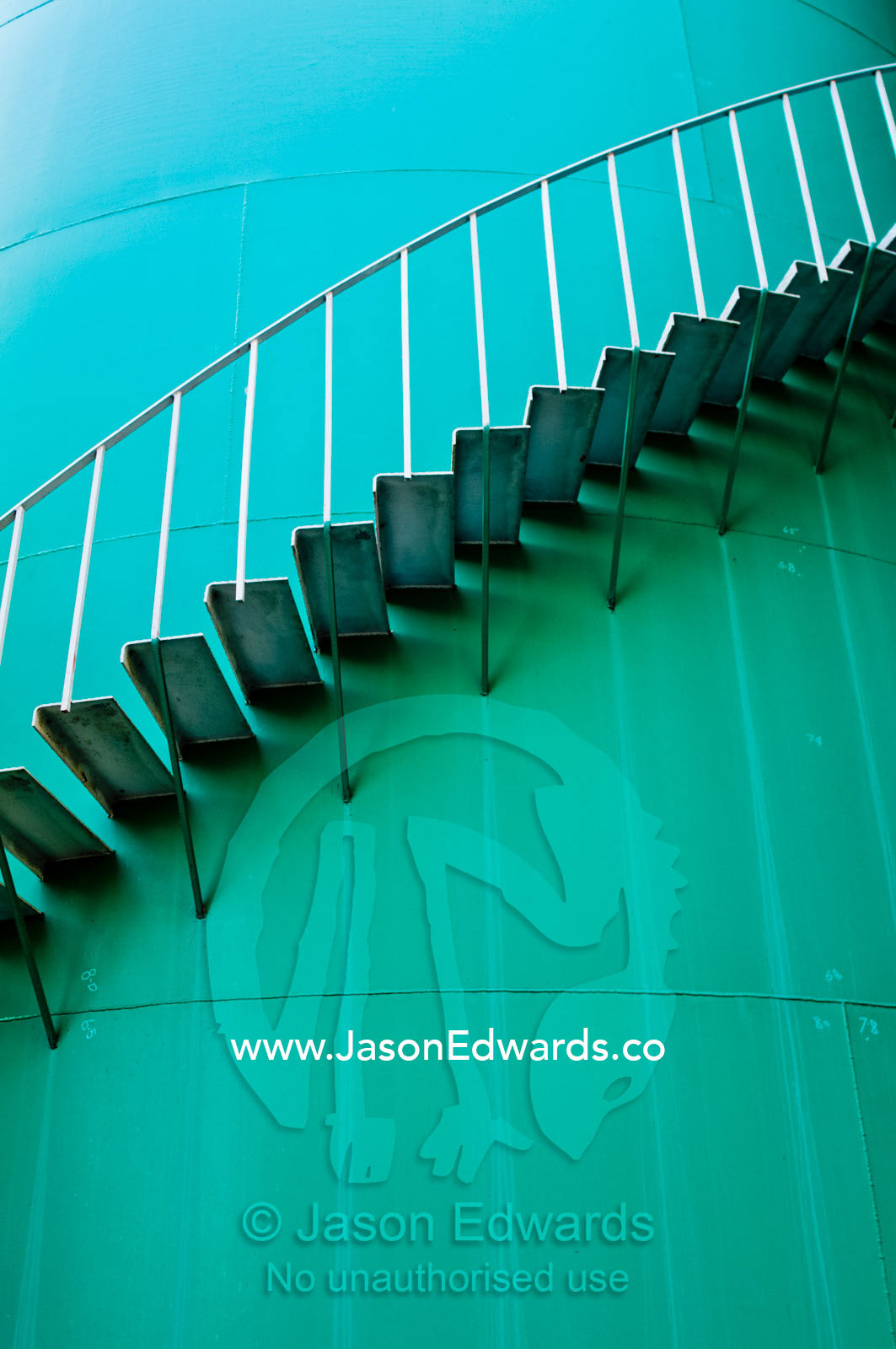 Stairs spiral around the wall of a turquoise airport deluge water tank. Kingsford Smith Airport, Mascot, Sydney, New South Wales, Australia.