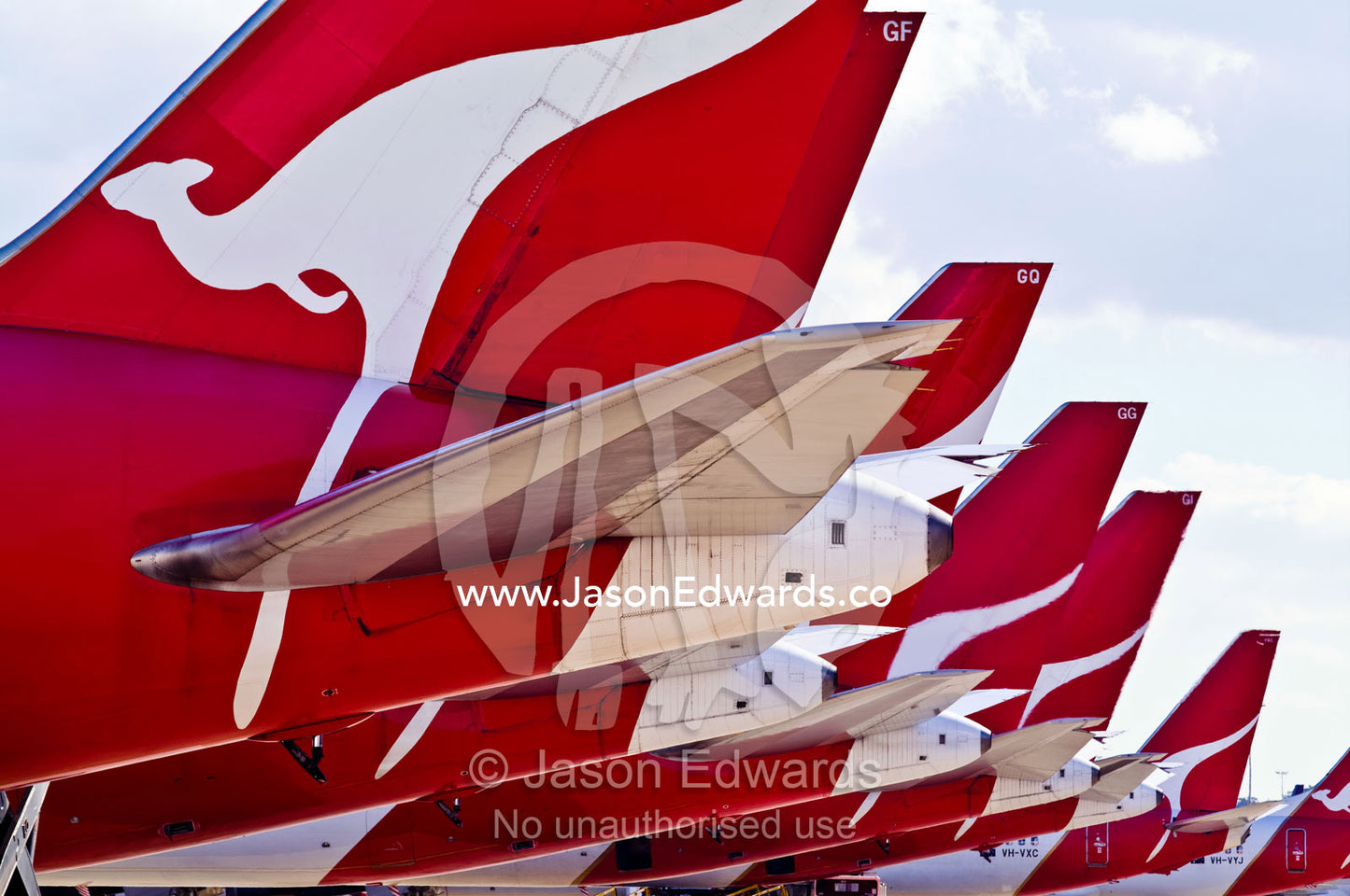 A row of jet airplanes parked at a terminal to collect passengers. Kingsford Smith Airport, Mascot, Sydney, New South Wales, Australia.