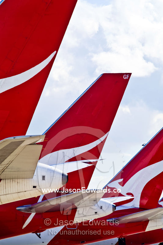 A row of jet airplanes parked at a terminal to collect passengers. Kingsford Smith Airport, Mascot, Sydney, New South Wales, Australia.
