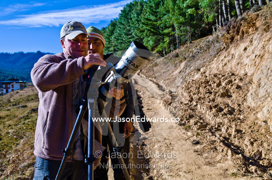 A photographer and his assistant do a field repair to a camera lens. Phobjikha Conservation Area, Phobjika Valley, Phobjikha Valley, Gangteng Valley, Black Mountains, Bhutan.