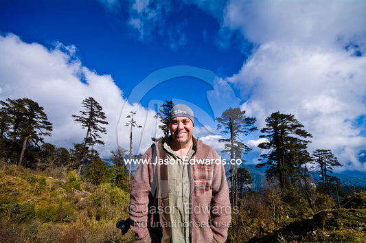 A photographer standing on a mountain pass in the Himalaya. 108 Druk Wangyal Khangzang Chortens, Dochula Pass, Thimphu District, Bhutan.