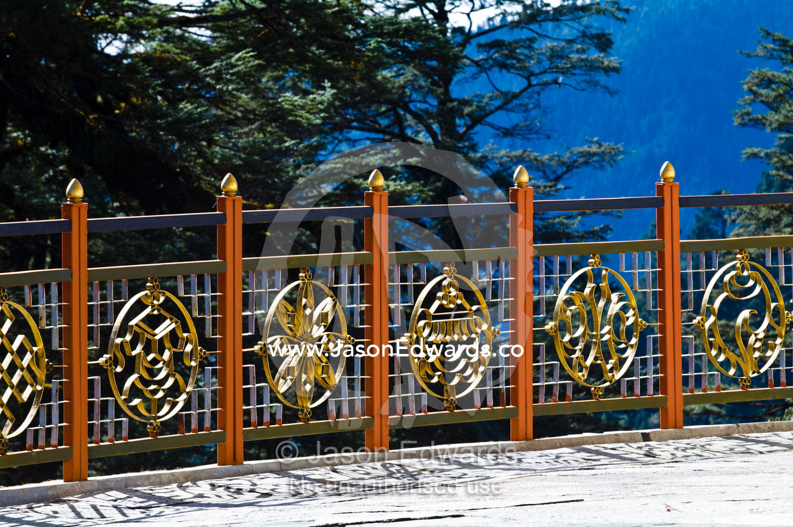An ornate golden war memorial fence with various religious symbols. 108 Druk Wangyal Khangzang Chortens, Dochula Pass, Thimphu District, Bhutan.