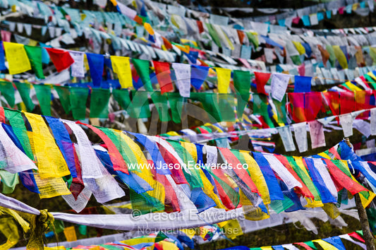 A canopy of colorful prayer flags flutter on a Himalayan mountain. 108 Druk Wangyal Khangzang Chortens, Dochula Pass, Thimphu District, Bhutan.