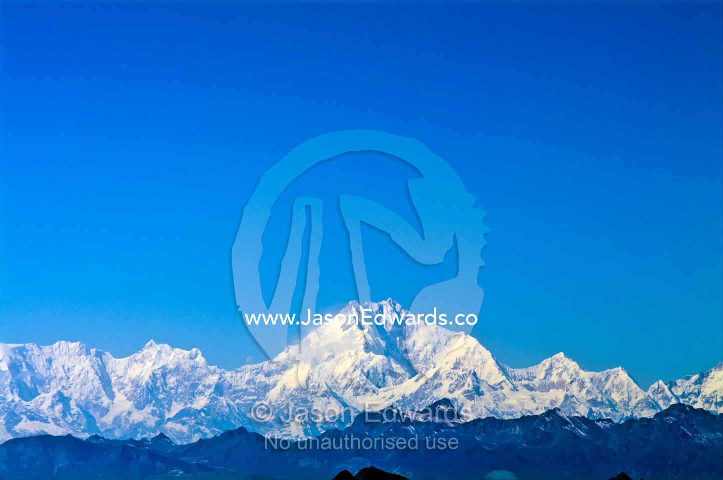 The jagged snow and ice summit of Mount Everest under a blue sky. Mount Everest, Himalayan Mountains, Bhutan.