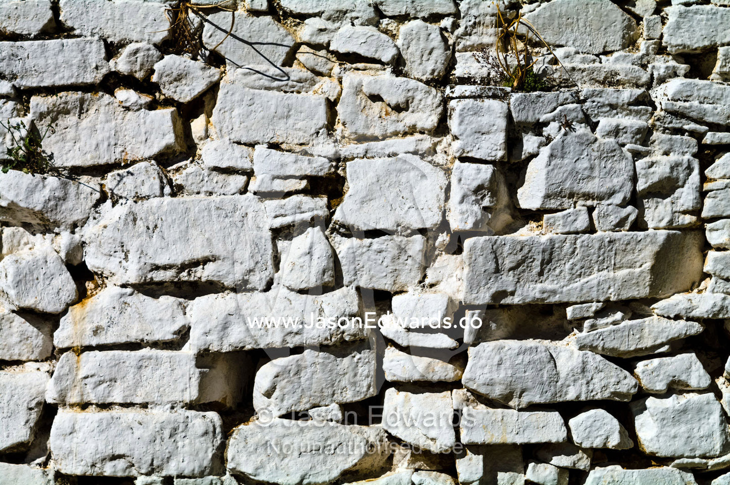 Hand-cut stones painted white form a wall in a Buddhist monastery. Rinpung Dzong, Paro Dzong, Paro, Paro District, Bhutan.