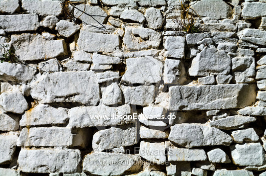 Hand-cut stones painted white form a wall in a Buddhist monastery. Rinpung Dzong, Paro Dzong, Paro, Paro District, Bhutan.