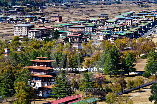 A housing community and government building beneath the ramparts of Rinpung Dzong. Rinpung Dzong, Paro Dzong, Paro, Paro District, Bhutan.